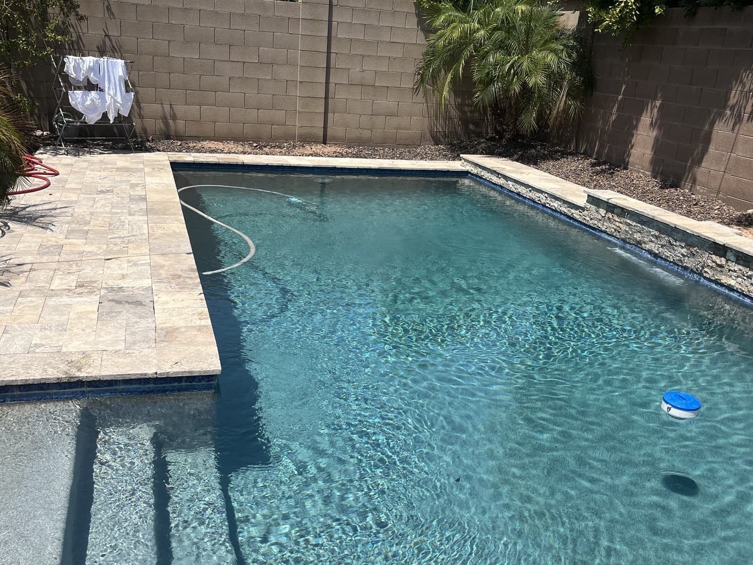 Crystal-clear backyard pool with water feature serviced by Flow State Pool Services in Peoria, AZ